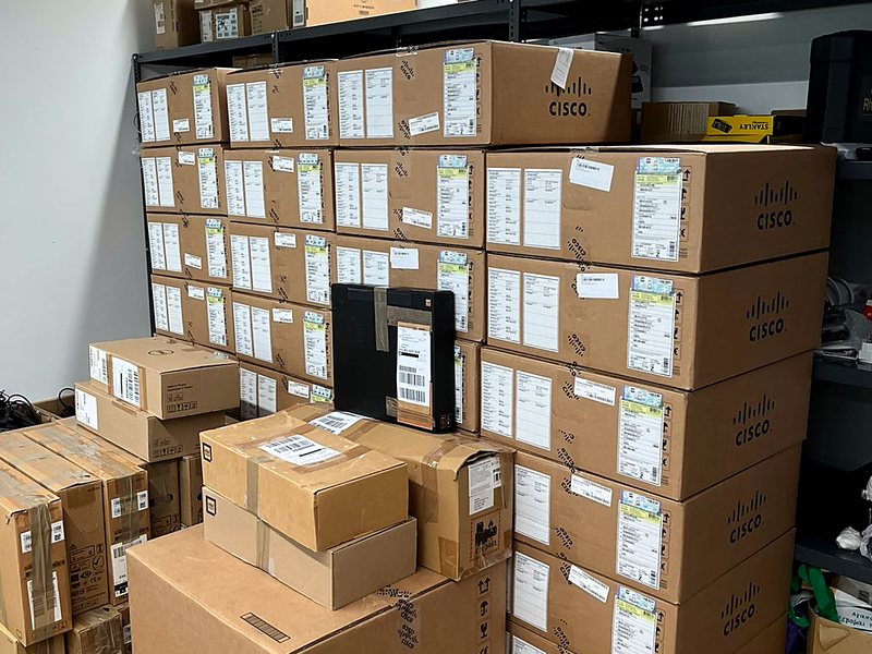 Stockroom with stacked Cisco network equipment boxes staged for deployment