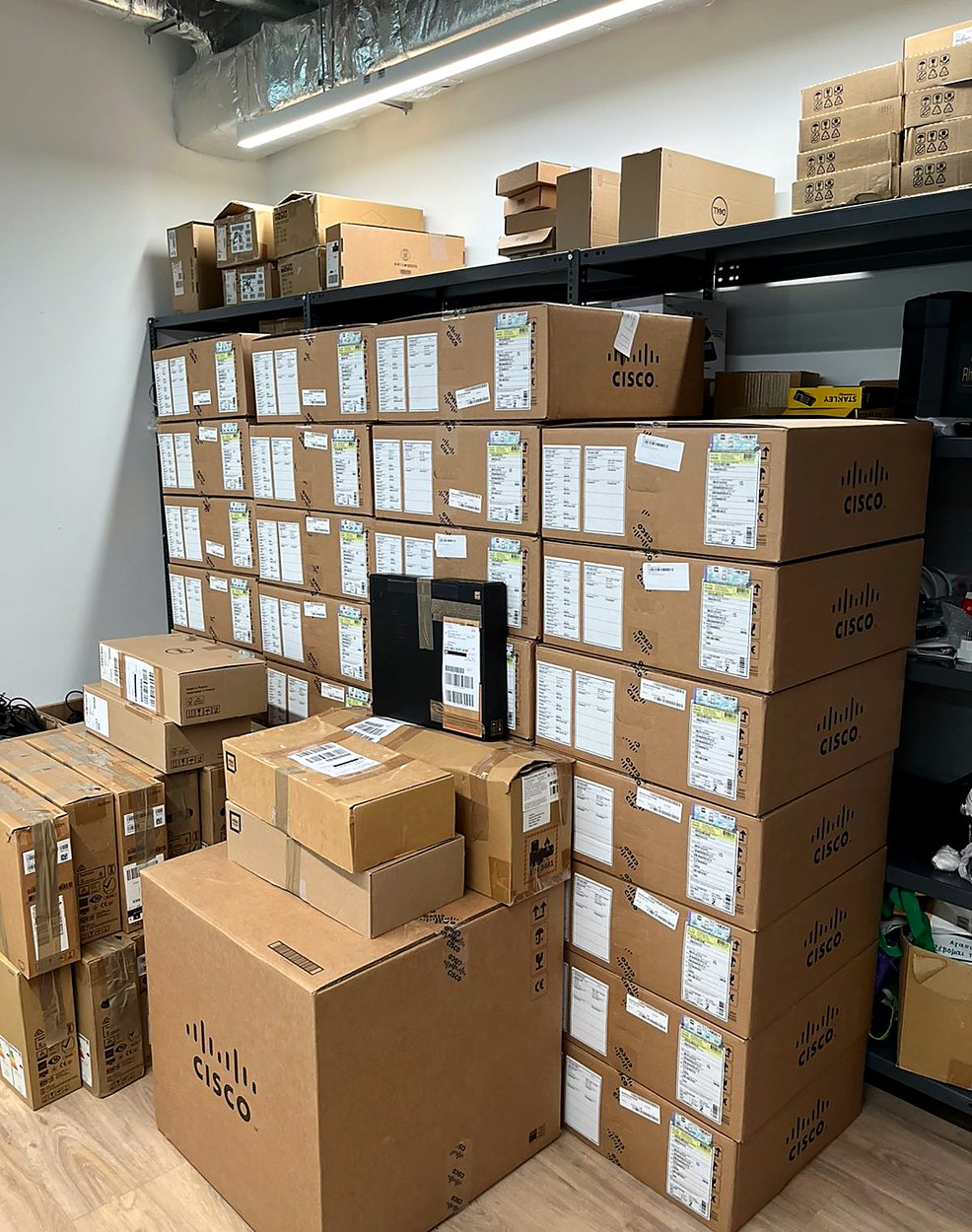 Stockroom with stacked Cisco network equipment boxes staged for deployment