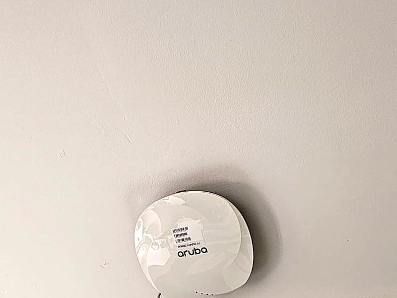 Aruba Wi-Fi access point mounted on a ceiling in an office