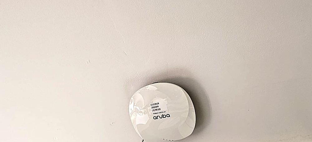 Aruba Wi-Fi access point mounted on a ceiling in an office